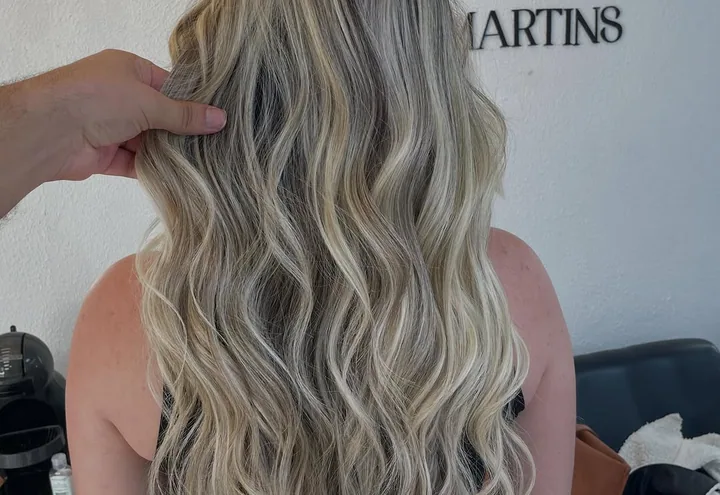 Cabelo loiro com mechas em ondas longas, visto de costas