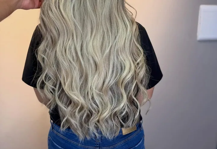 Cabelo loiro platinado ondulado, visto de costas
