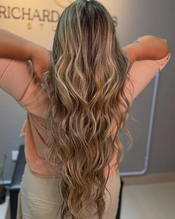 Cabelo castanho claro longo com mechas em ondas, visto de costas
