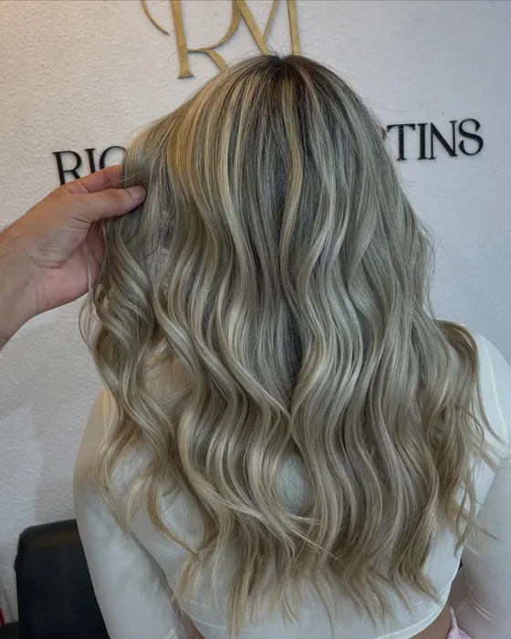 Cabelo loiro com mechas em ondas longas, visto de costas